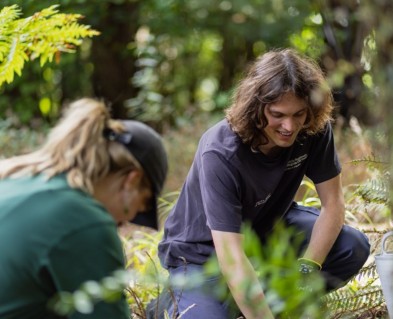 A image of Horticulture Apprentices Clem and Cloud, gardening in Ōtari-Wilton's Bush while smiling. 