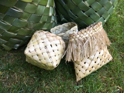 Image of three dried woven flax baskets against two large fresh woven baskets